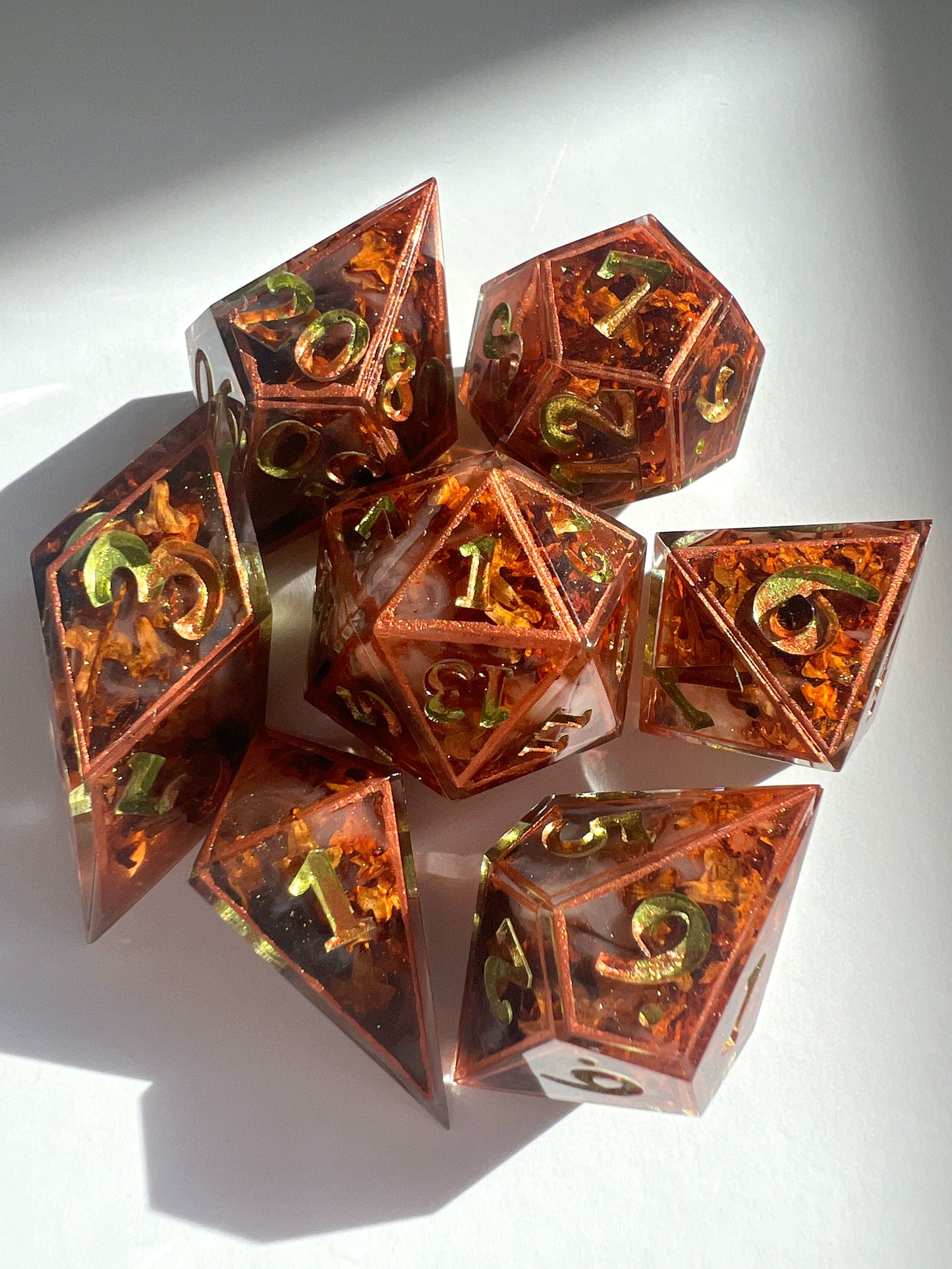 This 7-piece resin dice set includes tiny dried leaves, hand-painted copper borders and gold-to-green gradient numbers.