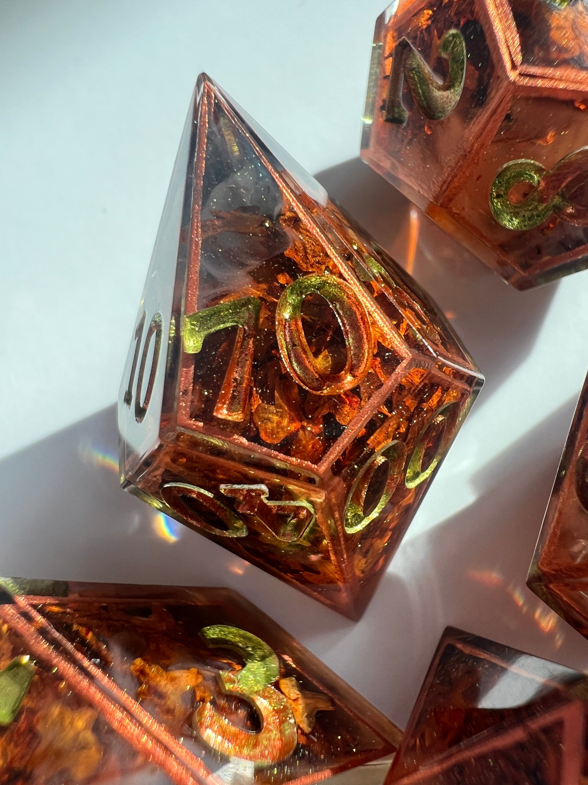 This 7-piece resin dice set includes tiny dried leaves, hand-painted copper borders and gold-to-green gradient numbers.