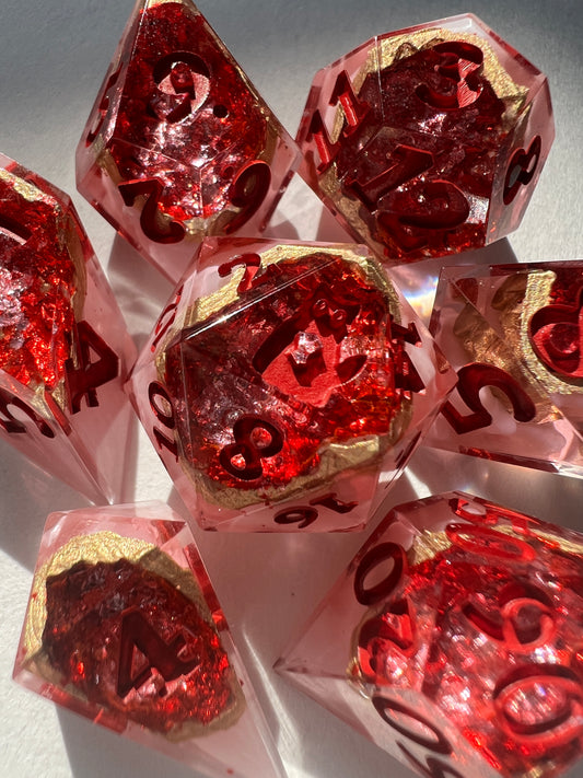 7-piece resin dice set made to look like geodes containing red crystals.