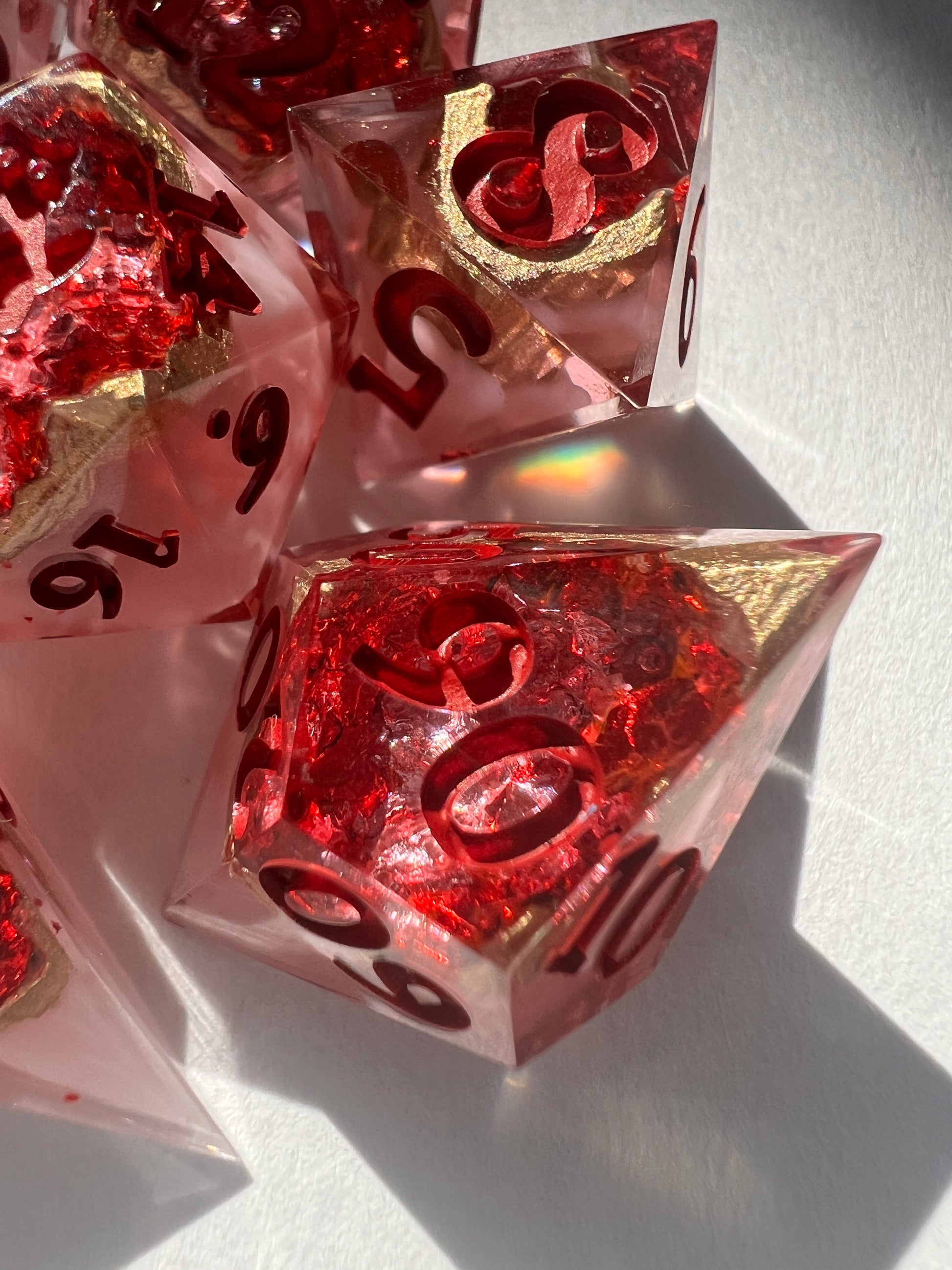 7-piece resin dice set made to look like geodes containing red crystals.