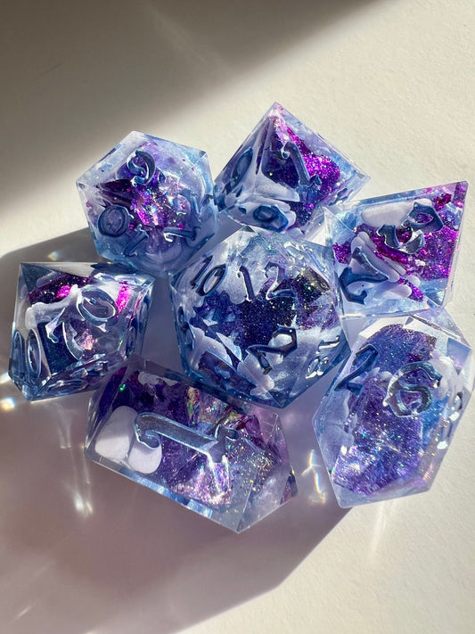 Polyhedral resin dice set with lavender bloops, purple foil and shimmery blue numbers.